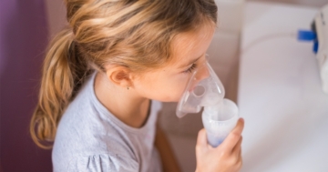 Bambina che utilizza la mascherina per la terapia con aerosol