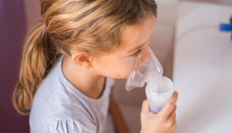 Bambina che utilizza la mascherina per la terapia con aerosol