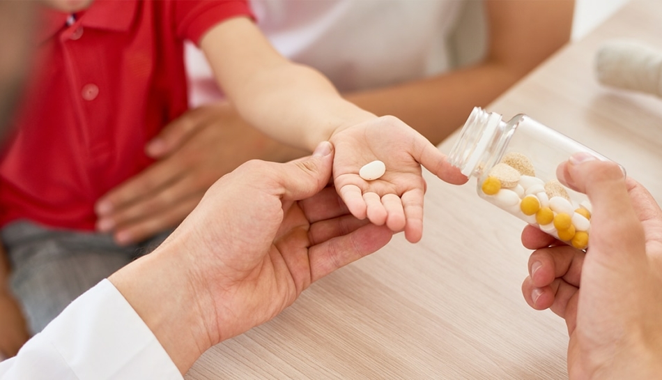 Mano di bambino cui vengono dati dei farmaci