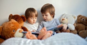 Due fratellini che leggono uno accanto all'altro