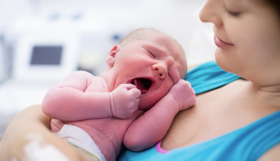 Mamma con in braccio un neonato subito dopo il parto