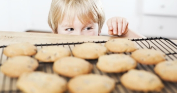 Bambino davanti a un'infornata di biscotti