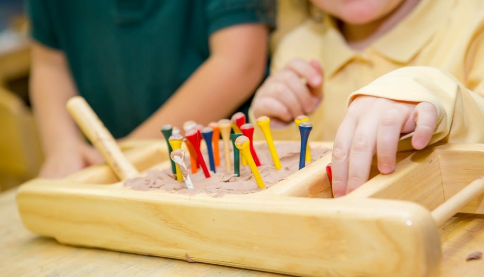 Bambino gioca con materiali sensoriali Montessori