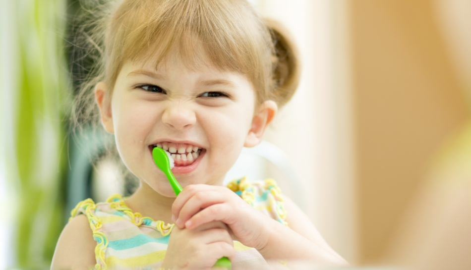Una bambina che si lava i denti con dentifricio fatto in casa