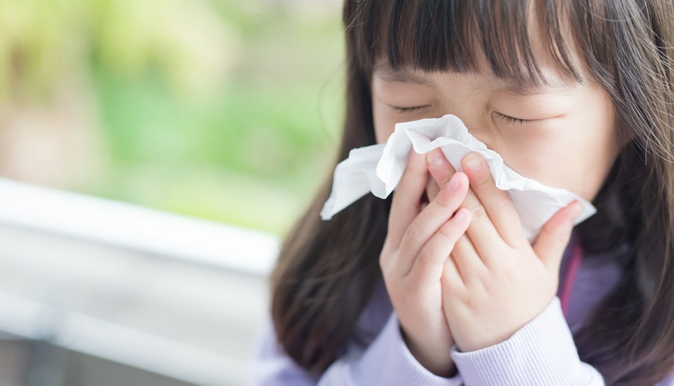 Bambina affetta da asma si soffia il naso