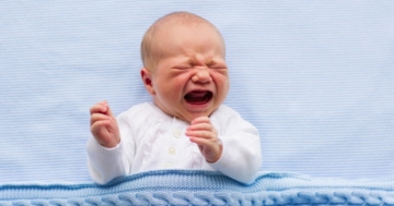 Un neonato che piange nella culla