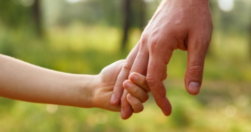 Child shakes father's hand