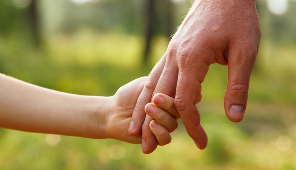 Bambino stringe la mano del padre