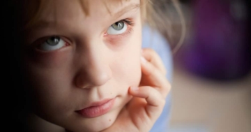 Primo piano di bambina con lo sguardo verso l'alto