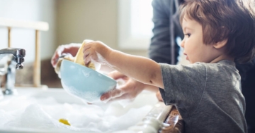 The child learns to wash dishes