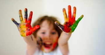Bambino che mostra le mani colorate a regola d'arte