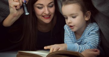 Mamma e bambina che leggono insieme