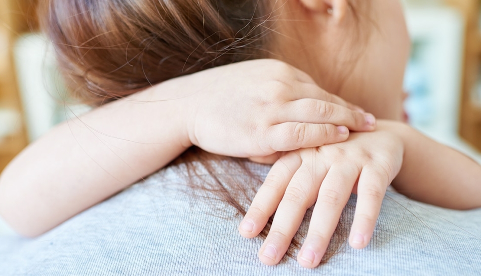 Mamma di schiena che si abbraccia con la figlia