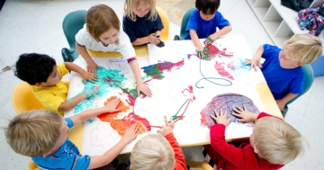 Kindergarten children working together on drawing