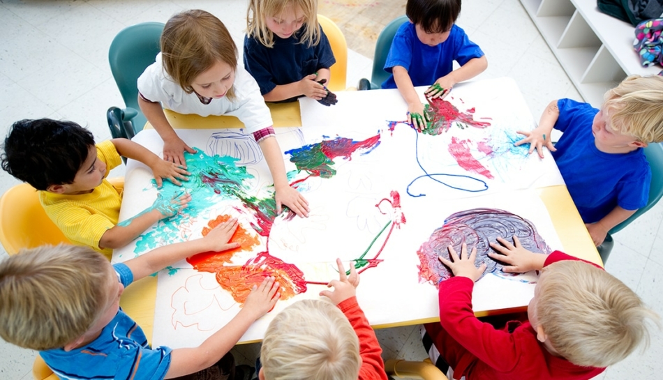 Bambini di un asilo che cooperano nel disegno