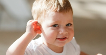 Bambino che presta attenzione mettendo una mano sull'orecchio