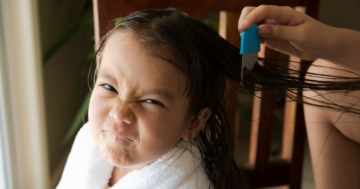 Bambina colpita da pidocchi con pettine a denti fitti