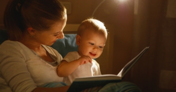 Mamma con bambino che legge un libro per imparare a parlare