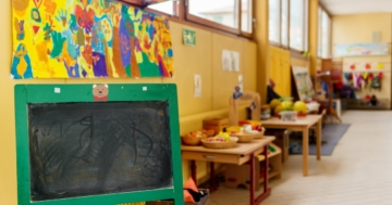 Aula di una scuola dell'infanzia o di un nido con lavagna in primo piano