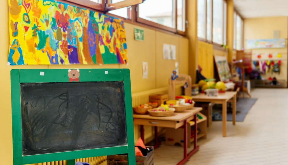 Aula di una scuola dell'infanzia o di un nido con lavagna in primo piano