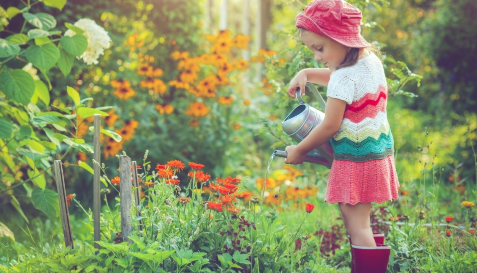 Bambina che annaffia in autonomia delle piante