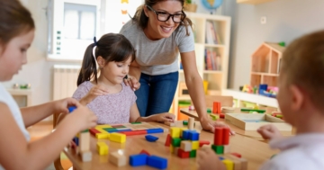 The teacher plays with the children in the kindergarten