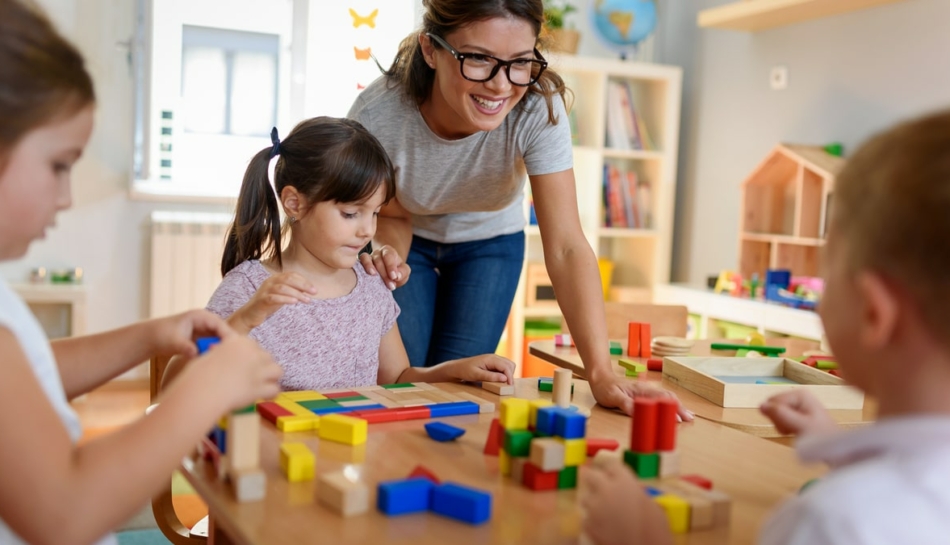 Maestra gioca con bambini alla scuola dell'infanzia