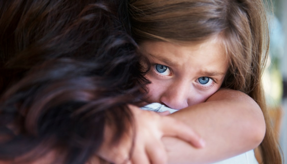 Primo piano di una bambina che abbraccia forte la mamma