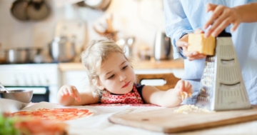 Bambina che aiuta la mamma a preparare il cibo