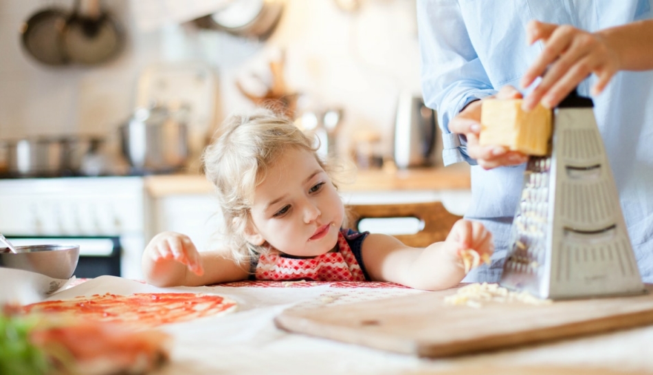 Bambina che aiuta la mamma a preparare il cibo