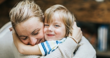 Mamma e bambino che si fanno le coccole con un abbraccio