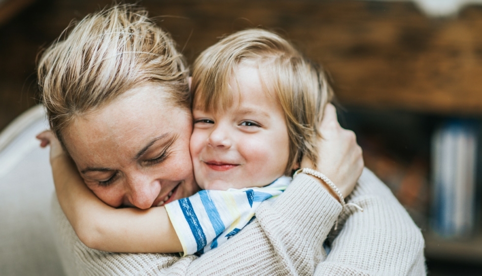 Mamma e bambino che si fanno le coccole con un abbraccio