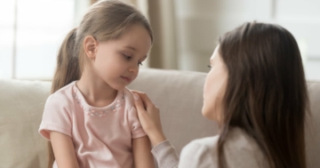 A mother talking to a little girl to explain something