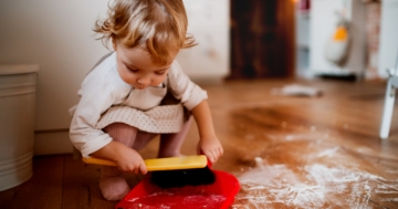 The child helps tidy up the house