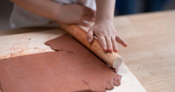 primo piano delle mani di una bambina che lavora l'argilla