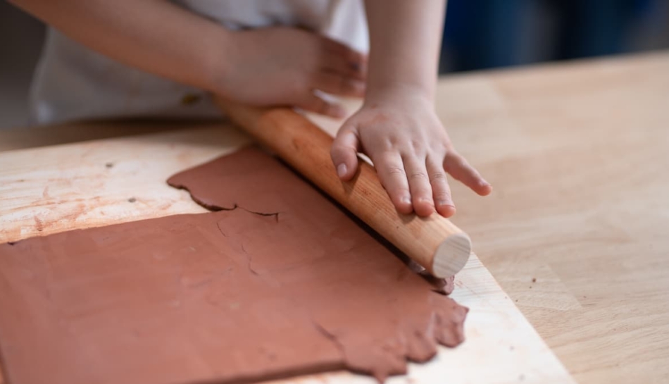 primo piano delle mani di una bambina che lavora l'argilla