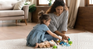 mamma e bambina che giocano insieme sul tappeto