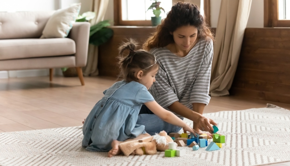 mamma e bambina che giocano insieme sul tappeto