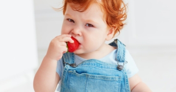 Bambino mangia una fragola