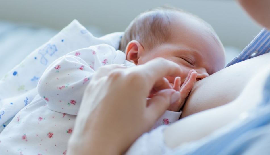 Neonato si nutre di colostro dal seno della madre