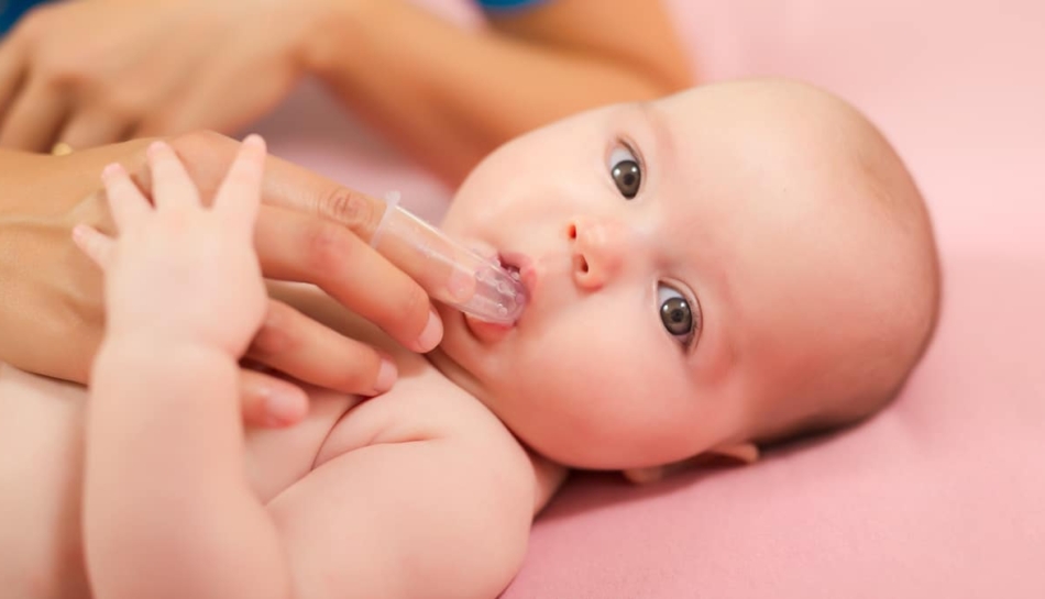 Madre lava i denti del suo bambino