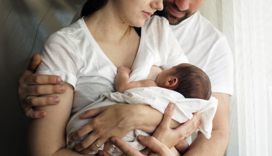 Papà abbraccia la sua compagna durante l'allattamento