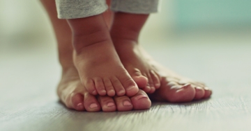 Piedi del bambino su quelli del genitore