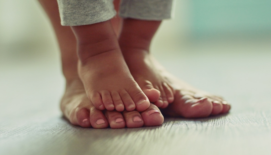 Piedi del bambino su quelli del genitore