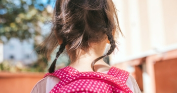 close-up of little girl from behind with backpack