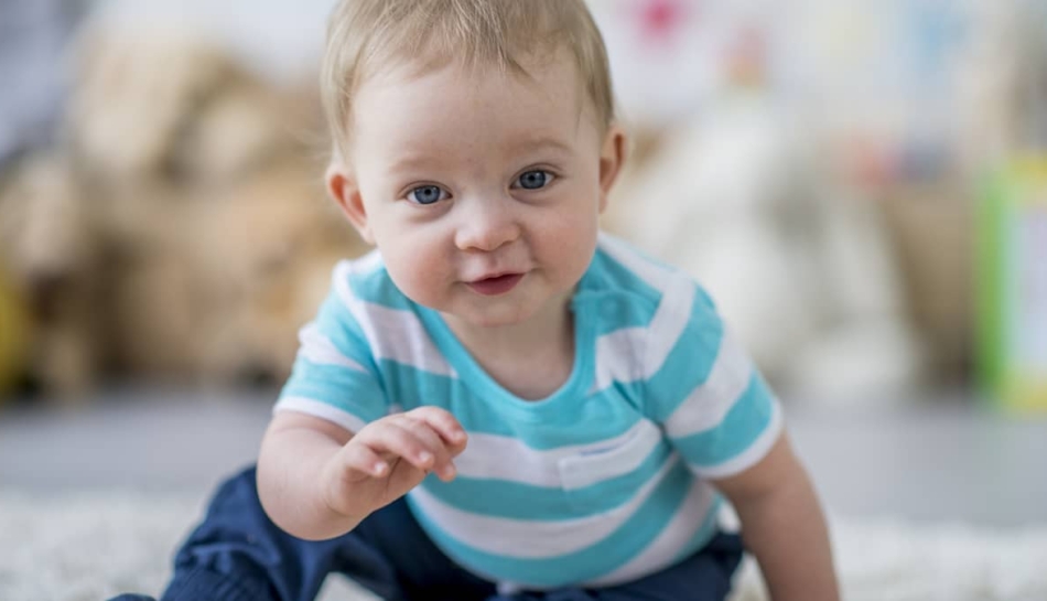 Bambino di 7 mesi seduto a terra