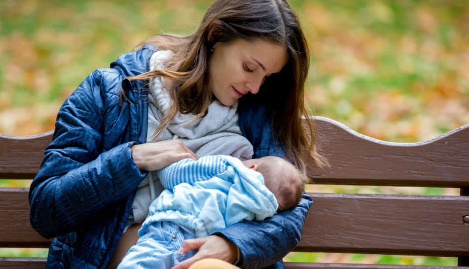 Mamma allatta il suo bambino in uno spazio pubblico