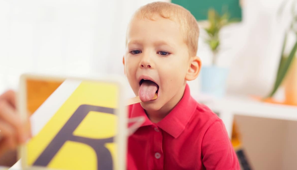 bambino che fa esercizi dal logopedista per difficoltà fonologiche