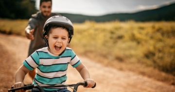 Bambino che impara ad andare in bicicletta da solo