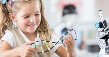 Bambina studia il modello a doppia elica del DNA